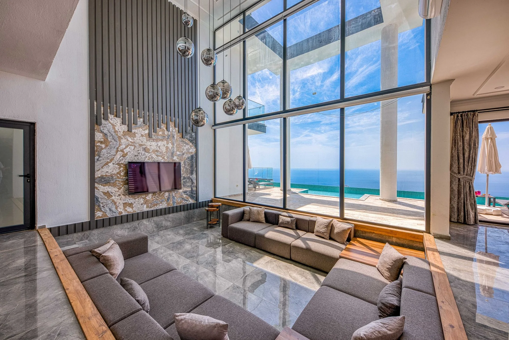 Bright coastal living room with floor-to-ceiling windows and an ocean view
